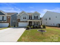 Charming two-story home with stone accents, manicured lawn, and inviting front porch at 184 Tetcott St, Mooresville, NC 28115