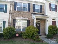 Charming two-story townhome with brick facade, black shutters, and a well-manicured front yard at 1960 Aston Mill Pl, Charlotte, NC 28273