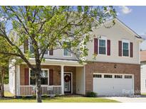 Charming two-story home features a brick facade, red shutters, and a cozy front porch perfect for relaxing at 221 Sycamore Creek Rd, Fort Mill, SC 29708