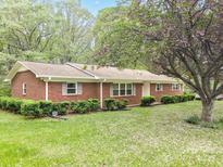 Charming red brick home with mature landscaping and a blooming tree in the front yard at 2582 Ivey Church Rd, Lincolnton, NC 28092