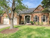 Charming brick home featuring manicured lawn, arched entry, and two car garage at 3017 Planters Walk Ct, Charlotte, NC 28210