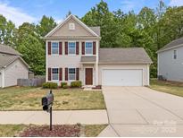 Charming two-story home with a well-maintained lawn and attached two-car garage at 303 Landis Oak Way, Landis, NC 28088