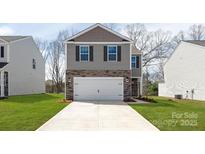 Charming two-story home featuring stone accents and a two-car garage, complemented by a well-manicured lawn at 3056 Ora Smith Rd, Lincolnton, NC 28092