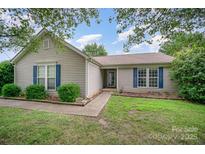Charming single-story home featuring blue shutters, a well-manicured lawn, and a welcoming front porch at 3606 White Swan Ct, Indian Trail, NC 28079