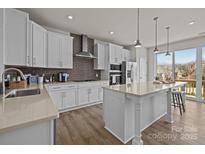 Modern kitchen featuring white cabinets, an island with pendant lighting and stainless steel appliances at 4100 Alexander View Dr # 1, Charlotte, NC 28226