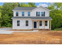 Charming two-story home featuring a welcoming front porch and freshly landscaped yard on a sunny day at 4175 River Run Cir, Hickory, NC 28602