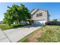 Charming two-story home with a well-maintained lawn, a mature tree, and a driveway leading to a two-car garage at 4315 Barnside Ln, Charlotte, NC 28216