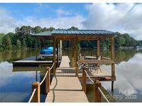 Beautiful dock featuring a boat slip, covered seating area, and stunning lake views perfect for relaxation and entertainment at 6778 Emerald Isle Dr, Sherrills Ford, NC 28673