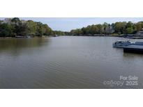 Scenic lake view with surrounding trees and waterfront homes showcasing the serene lakeside lifestyle at 6778 Emerald Isle Dr, Sherrills Ford, NC 28673
