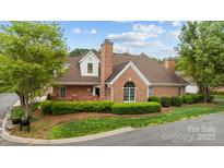 Beautiful brick home features mature landscaping, a prominent chimney, and well-manicured lawn at 7502 Hurstbourne Green Dr, Charlotte, NC 28277