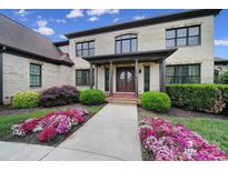 Elegant front entrance with a double door, covered porch, and blooming flower beds at 802 Capington Ln, Waxhaw, NC 28173