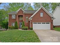 Beautiful two-story brick home with well-manicured lawn and attached two-car garage at 8600 Glade Ct, Huntersville, NC 28078