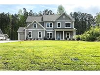 Large, gray two-story home with lush green lawn and meticulously landscaped front yard at 117 Blackbeard Ln, Mooresville, NC 28117