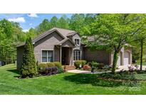 Charming single-Gathering home featuring a brick exterior, well-manicured lawn, and lush landscaping at 1590 W 7Th St, Newton, NC 28658
