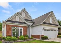 Charming single-story home with brick and siding exterior, manicured lawn, and attached two-car garage at 20135 Dovekie Ln, Fort Mill, SC 29707