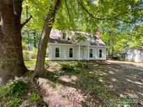 Charming two-story home with white siding and mature trees providing shade at 2113 Killarney Pl, Charlotte, NC 28262