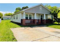 Charming single-story home featuring a cozy front porch and a spacious concrete driveway at 2311 Sherrill St, Charlotte, NC 28208