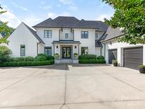 Stunning white brick two-story home with a black roof, manicured landscaping, and a spacious concrete driveway at 2343 Vernon Dr, Charlotte, NC 28211