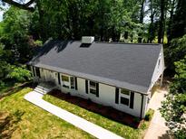 Beautifully renovated home featuring a classic white exterior, black shutters, and a well-manicured lawn at 2601 Pinewood Rd, Gastonia, NC 28054