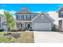 Charming two-story home with a well-manicured lawn and inviting two-car garage at 3153 Pinehills Way, Mount Holly, NC 28120