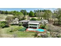 Stunning aerial view of a traditional-style home with a private pool and lush green landscaping on a golf course at 455 W Gleneagles Rd, Statesville, NC 28625