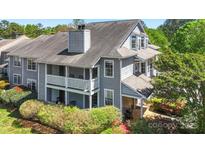 Attractive gray two-story home with a covered balcony and lush, mature landscaping at 6053 Treetop Ct, Charlotte, NC 28212