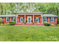Charming brick home with a welcoming front porch and rocking chairs at 722 12Th Nw Ave, Hickory, NC 28601