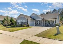 Charming single Gathering home with a long driveway, attached garage, and covered front porch with rocking chairs at 8011 Green Heron Ct, Belmont, NC 28012