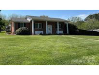 Charming brick home with a manicured lawn and white pillars accenting the front entrance at 901 Ridge St, Albemarle, NC 28001