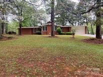 Charming single-story brick home with well-manicured lawn and mature trees at 1012 Hawkinstown Rd, Salisbury, NC 28144