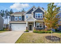 Charming two-story home featuring a two car garage and stone accents on the front facade at 117 Rooster Tail Ln, Troutman, NC 28166