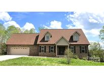 Charming brick home featuring a well-manicured lawn and two-car garage at 1592 Farmington Hills Dr, Conover, NC 28613
