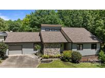 Attractive home with stone facade, brown roof, manicured lawn, and an attached garage at 16070 Palawan Ct, Tega Cay, SC 29708