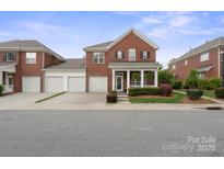 Charming brick home featuring a welcoming front porch, well-maintained landscaping, and a spacious two-car garage at 20217 Middletown Rd, Cornelius, NC 28031
