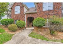 Charming brick condo building featuring an arched entryway and well-manicured landscaping at 2515 Carya Pond Ln, Charlotte, NC 28212