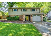 Charming two-story home with brick and vinyl siding, attached garage, and well-manicured lawn at 4224 Firwood Ln, Charlotte, NC 28209