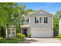 Charming two-story home with a well-manicured lawn, two-car garage, and classic architectural details at 5611 Hammermill Dr, Harrisburg, NC 28075