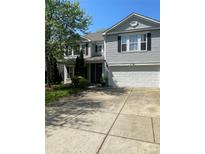 Two-story home with vinyl siding, a two-car garage, manicured lawn and mature shade tree at 5611 Hammermill Dr, Harrisburg, NC 28075