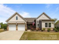 Charming home with a well-manicured lawn, brick accents, and a welcoming two-car garage at 8018 Green Heron Ct, Belmont, NC 28012