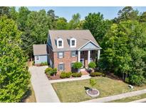 Beautiful brick home with dormer windows, a spacious front yard, and a long driveway at 9810 Daufuskie Dr, Charlotte, NC 28278
