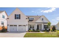 Charming two-story home featuring a two-car garage, landscaped yard, and welcoming front porch at 13063 Arnold Palmer Cir # 839, Lancaster, SC 29720