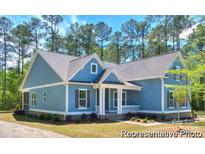 Charming single-story home boasts light blue siding, a covered front porch, and lush landscaping at 13063 Arnold Palmer Cir # 839, Lancaster, SC 29720