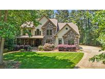 Charming home with stone accents, lush landscaping, and a welcoming front porch at 14130 Lea Point Ct, Huntersville, NC 28078