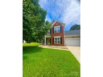 Charming two-story home with a well-manicured lawn and a combination brick and siding exterior at 15003 Jerpoint Abby Dr, Charlotte, NC 28273