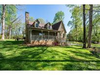 Charming stone-accented home featuring a cozy front porch and well-manicured lawn at 1524 Court Cir, Newton, NC 28658
