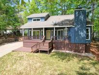 Charming blue home featuring a covered front porch, wooden deck, and lush green lawn at 16149 Haroa Ct, Tega Cay, SC 29708