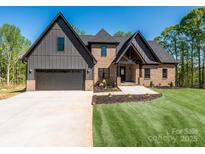 Beautiful two-story home with brick and gray siding, complemented by a well-manicured lawn and a wide driveway at 2008 Plain Field Dr, Bessemer City, NC 28016