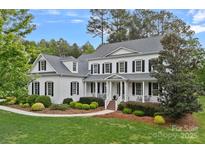 Charming white two-story home with black shutters, a welcoming porch, and manicured landscaping at 208 Grasshopper Cir, Mooresville, NC 28117