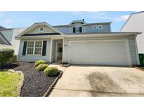 Charming home features a 2-car garage and beautiful landscaping with a well-maintained lawn and decorative bushes at 4437 Devonhill Ln, Charlotte, NC 28269