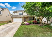 Charming two-story home featuring a well-manicured lawn, brick accents, and an inviting front porch at 575 Marthas View Nw Dr, Huntersville, NC 28078
